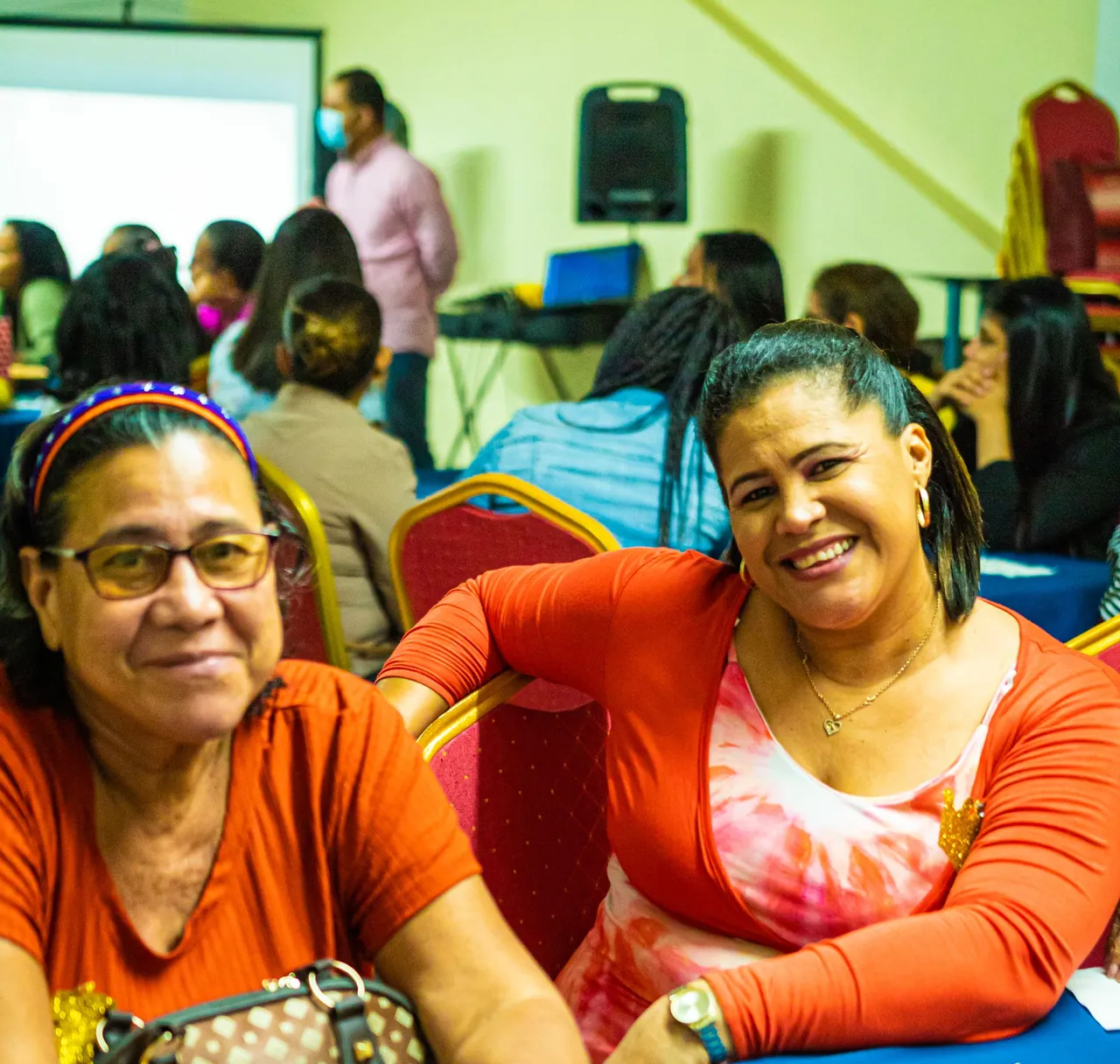 Two women smiling at a table during a community workshop