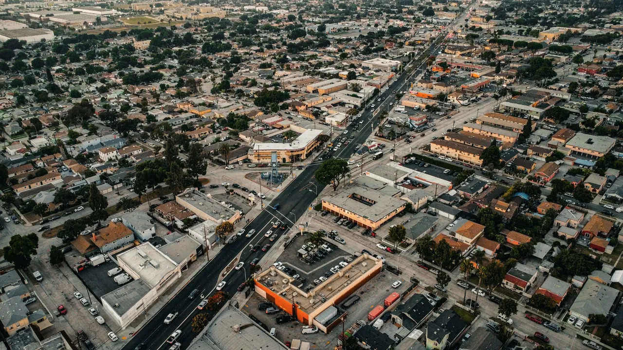 A Los Angeles neighborhood of homes, shops and streets from the air at dusk